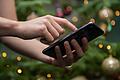 Eine Frau tippt auf ihrem Smartphone       -  Die traditionelle Weihnachtskarte verliert an Bedeutung: 62 % der Deutschen ab 16 Jahren verschicken digitale Grüße, zeigt eine Umfrage von Bitkom Research.