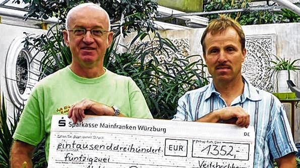 Ein Dank an die schöne Kristiana       -  (and)   Die Gartenbaugruppe Würzburg gehört zu den ganz treuen Spendern der Aktion Patenkind. Seit langem schon gibt's in den Mitgliedsgärtnereien einmal im Jahr die Benefiz-Geranie: Vom Verkaufspreis jeder einzelnen Geranie geht jeweils ein Euro an die Aktion Patenkind. &bdquo;Kristiana&ldquo;, so hieß die besonders schöne Geranie dieses Jahr, brachte insgesamt 1350 Euro. Den Scheck überreichten Obermeister Friedrich Reim (links) und Michael Heßdörfer von der Gärtnerei Heßdörfer in Retzbach. Nächstes Jahr feiert die Gartenbaugruppe ein Jubiläum: Dann gibt's die zehnte Benefiz-Geranie.