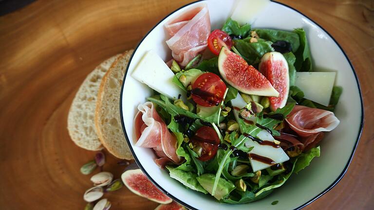 Salat Siciliano mit Schinken, gerösteten Pistazien und Feigen       -  In einem grünen Salat passen Schinken und geröstete Pistazien hervorragend zu Feigen.