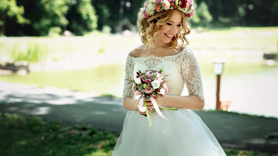 Braut mit Blumenkranz       -  Zu einer perfekten Hochzeit gehört ein perfektes Kleid - gleichzeitig muss sich die Braut aber auch wohlfühlen.