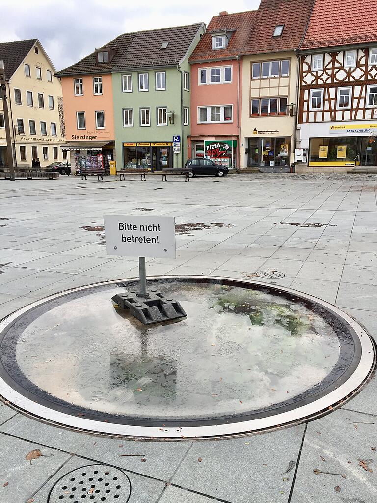 'Bitte nicht betreten': Die Glasscheibe über dem Brunnen am Marktplatz in Mellrichstadt wird bei Nässe rutschig. 'Bitte nicht betreten': Die Glasscheibe über dem Brunnen am Marktplatz in Mellrichstadt wird bei Nässe rutschig.