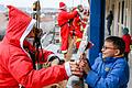 Ein Feuerwehr-Nikolaus beschenkt den&nbsp;kleinen Diego (12 Jahre alt) mit Süßigkeiten.