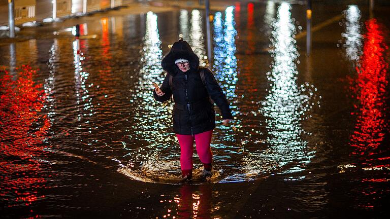 Wismar.jpeg       -  Eine Frau watet durch das Hochwasser am Stadthafen von Wismar.