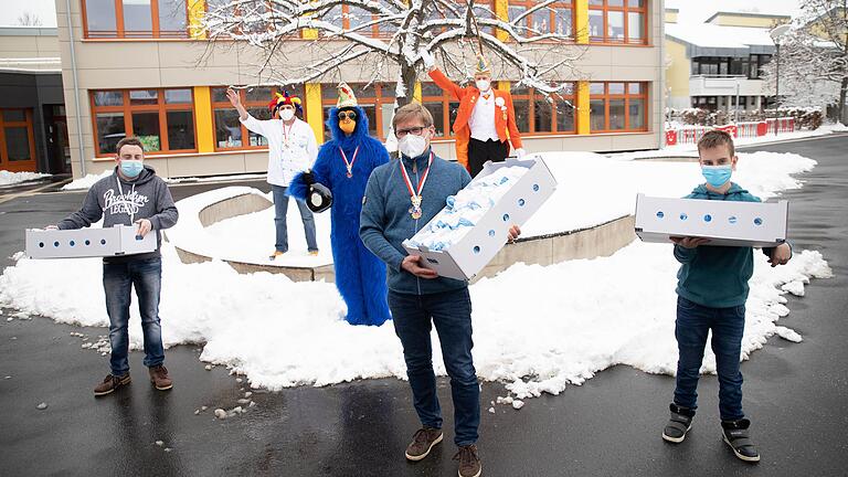 Faschingskrapfen für Würzburg: Der KaGe Elferrat verteilte 1111 Krapfen an verschiedene Einrichtungen in Würzburg, hier an der Graf-zu-Bentheim-Schule am Blindeninstitut. Hinten v.l.n.r.: Bäcker Christian Englert, die Symbolfigur 'Blauer Affe' des Elferrats, Ralph Rosenberger vom Elferrat. Vorne v.l.n.r.: Schüler Jason Hohl, stellvertretender Schulleiter Frank Tollkühn , Schüler Denis Wolf.