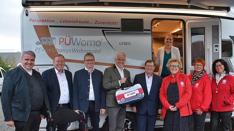 Ministerin Judith Gerlach war bei der Übergabe des neuen Pflegeübungswohnmobils&nbsp;(PÜWomo) auf dem Wohnmobilstellplatz der Frankentherme Bad Königshofen zu Gast. Mit dabei (von links) Domkapitular und Vorstandsvorsitzender des Caritasverbands für die Diözese Würzburg e. V.&nbsp; Clemens Bieber, Kurdirektor Werner Angermüller, Bürgermeister Thomas Helbling, MdL Steffen Vogel, stellvertretender Landrat Josef Demar, Angelika Ochs (Vorständin des Kreiscaritasverbandes Rhön-Grabfeld), Gudrun Rathgeber (Pflegedienstleitung Caritas St. Peter Bad Königshofen) sowie Ulli Feder (Pflegedienstleistung Caritas St. Kilian in Mellrichstadt).