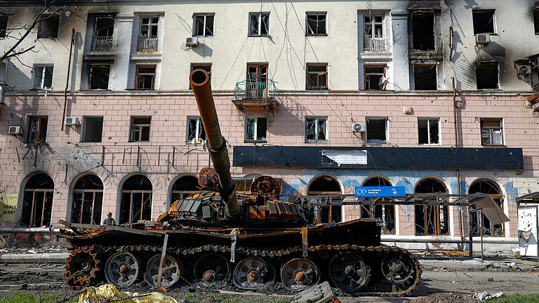 26.04.2022, Ukraine, Mariupol: Ein zerstörter Panzer und ein durch schwere Kämpfe beschädigtes Wohnhaus sind in einem von den von Russland unterstützten Separatisten kontrollierten Gebiet in Mariupol, Ukraine, zu sehen. Foto: Alexei Alexandrov/AP/dpa +++ dpa-Bildfunk +++