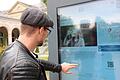 Ein Gast liest an der interaktiven Infostele im Kurgarten. Foto: Benedikt Borst       -  Ein Gast liest an der interaktiven Infostele im Kurgarten. Foto: Benedikt Borst