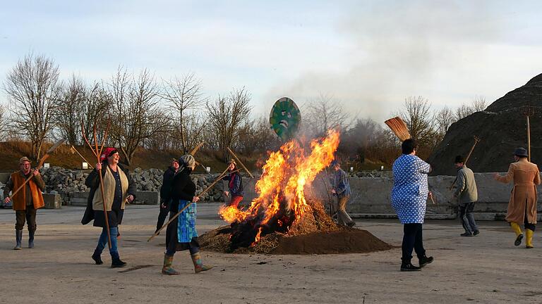 Freudiger Tanz der Bergtheimer Wengertsschneckli ums Feuer. Das Coronavirus soll aus dem Dorf verbannt werden.