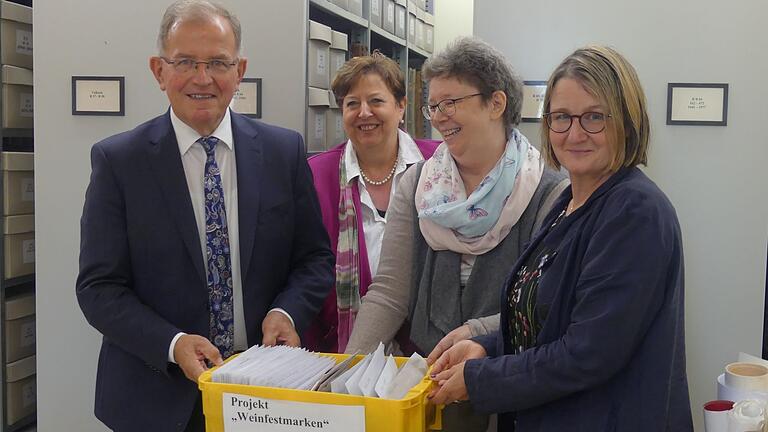 Bezirkstagspräsident Erwin Dotzel übergab zusammen mit Birgit Speckle, Kulturarbeit und Heimatpflege des Bezirks Unterfranken (rechts), die Sammlung der Weinfestmarken an die Leiterin des Volkacher Stadtarchivs, Ute Feuerbach. Im Hintergrund ist Volkachs Dritte Bürgermeisterin Gerlinde Martin zu sehen.