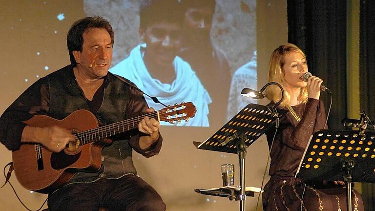 Bilder der Weihnacht: Clemens Bittlinger spielt Lieder für die Seele, hier begleitet er Sängerin Lara Hermann mit der Gitarre.