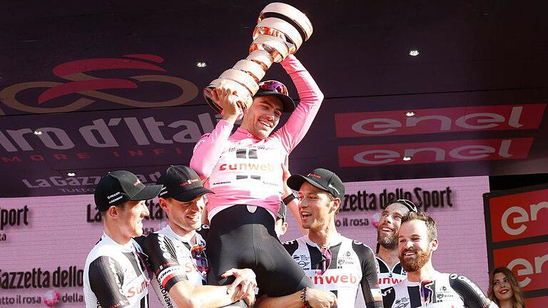 Triumph       -  Tom Dumoulin (M.) wurde nach seinem Giro-Sieg von seinen Teamkollegen auf Händen getragen. Foto: Yuzuru Sunada