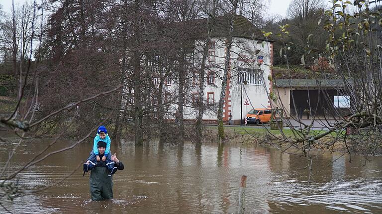 Jan Friedrich watete mit seinem Sohn am Weg zum Sportplatz durch das Hochwasser. Im Hintergrund ist das Gräfendorfer Rathaus zu sehen.