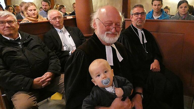 Ein anrührendes Bild: Opa Jahreiß beim Abschiedsgottesdienst entspannt mit dem Enkel auf dem Schoß, während die Schwiegertochter ein Lied singt. Rechts daneben Dekan Matthias Büttner.