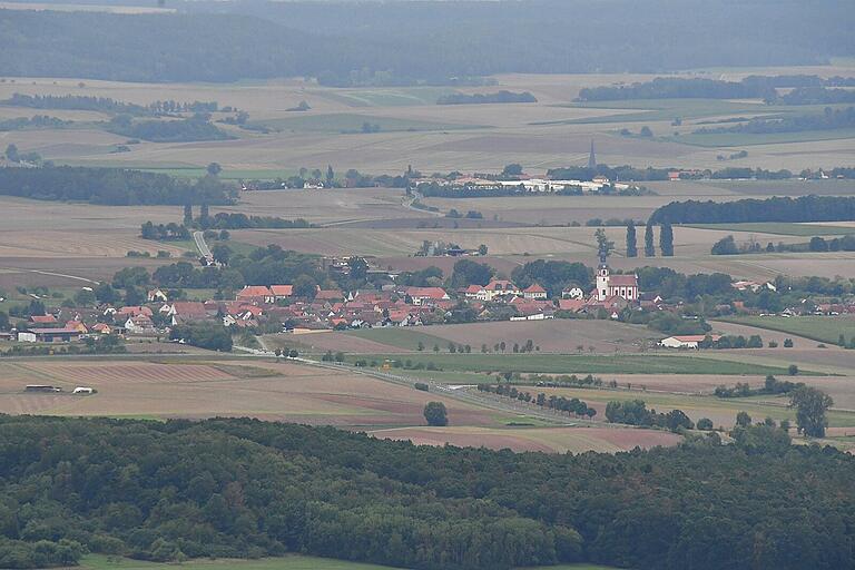 Ein Blick vom Großen Gleichberg auf das thüringische und fränkische Grabfeld. Trappstadt im Vordergrund, dahinter die Turmspitze von Alsleben