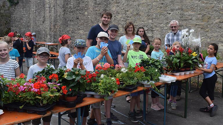 Blumenhändler Otto Blasczyk und stellvertretende Bürgermeisterin Rosa Behon übergaben Blumen an die Kinder des Ferienspielplatzes.