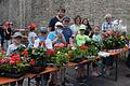 Blumenhändler Otto Blasczyk und stellvertretende Bürgermeisterin Rosa Behon übergaben Blumen an die Kinder des Ferienspielplatzes.