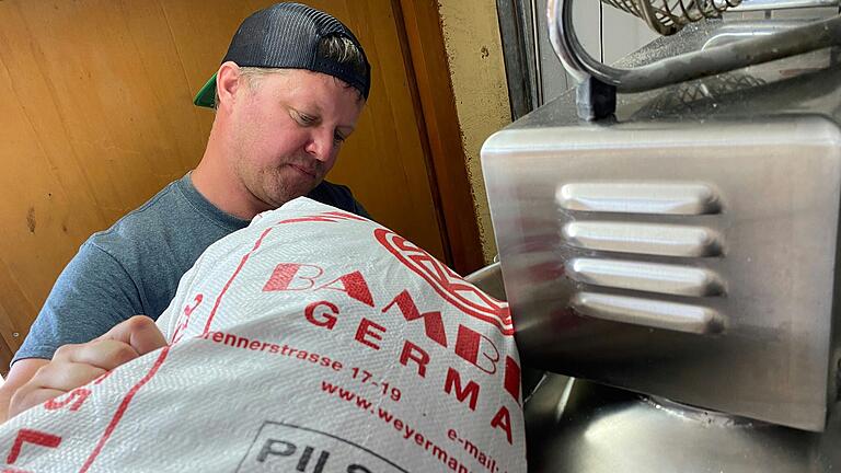 500 Liter fasst der Sudkessel der Goikelbräu. Das Malz füllt Braumeister Müller aus einem Sack hinein.