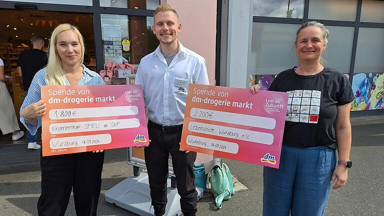 Konrad Ackermann (Filialleiter dm Zellerau) übergibt Schecks an Isabelle Zindler (Leitung Spieli) und Madlen Börner (Lebenshilfe Würzburg).