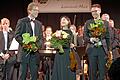 Lebenskraft der Musik verströmte das Windensemble in der Kürnacher Höllberghalle bei einem Benefizkonzert. Beim Abschlussapplaus freuten sich (vorne von links) Dirigent, Initiator und Organisator Wolfgang Heinrich, Solistin Sinn Yang und Moderator Julius Herion.