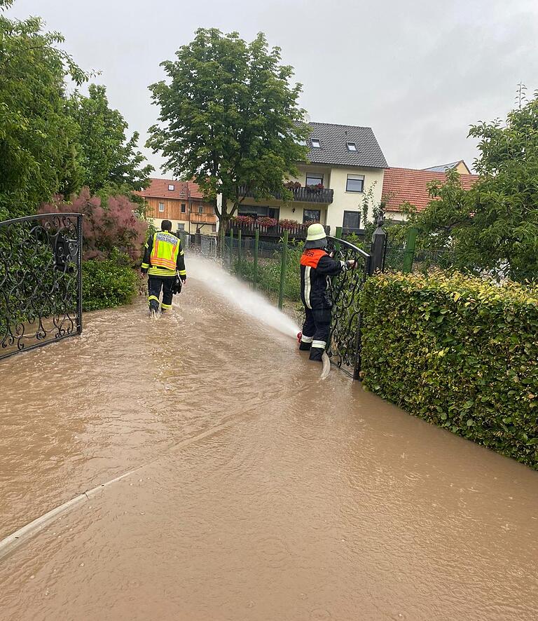 Feuerwehrleute kämpfen am Freitag in Dingolshausen gegen das Hochwasser. Feuerwehrleute kämpfen am Freitag in Dingolshausen gegen das Hochwasser.