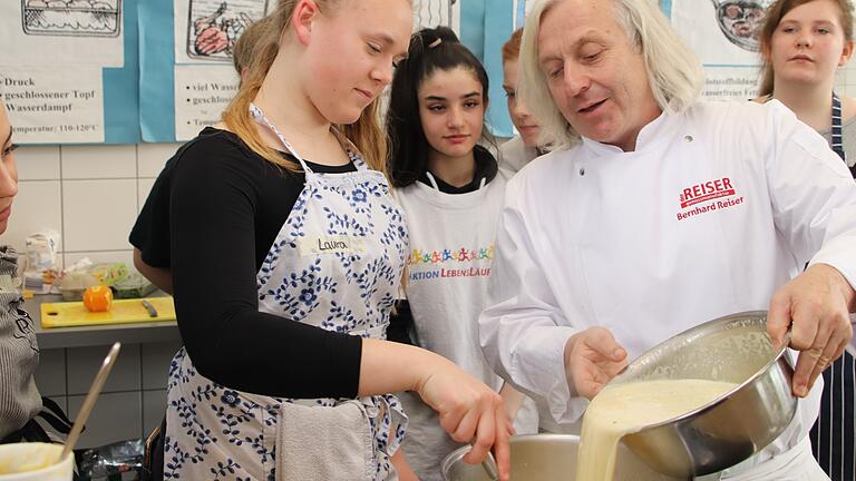 Die Schüler der 9. und 10. Klasse der Grund- und Mittelschule Iphofen kochen zusammen mit Sternekoch Bernhard Reiser. Gerade bereiten sie das Eis zu.