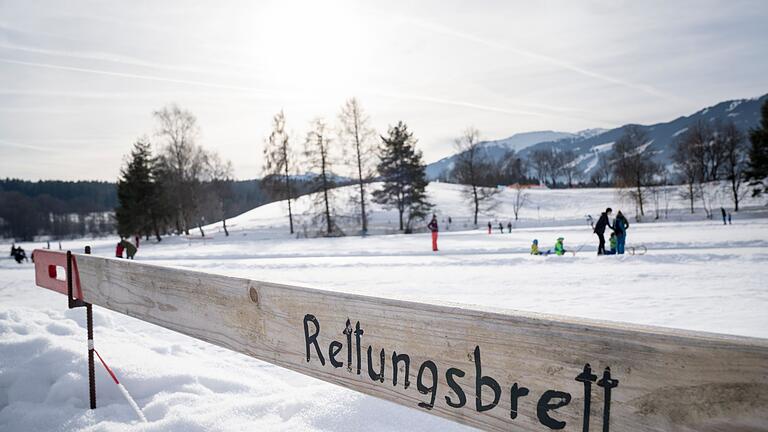Ein Rettungsbrett an einem zugefrorenen See       -  Eisflächen sind nur ab einer ausreichenden Dicke sicher begehbar: Bricht jemand ein, sollten Helfende vom Ufer aus Rettungshilfen wie Bretter, Leitern oder Äste nutzen, um die gefährdete Person an Land zu bringen.