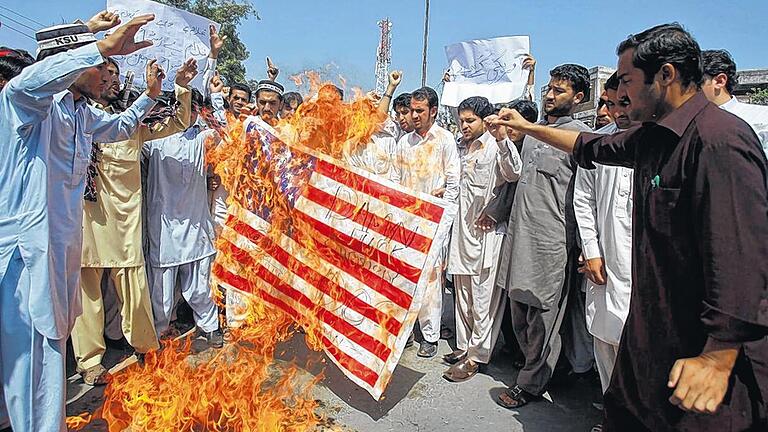 Anhaltende Proteste gegen das Schmähvideo: Studenten verbrennen in Peschawar eine US-Flagge. Pakistans Regierung hat den kommenden Freitag zum Nationalfeiertag zu Ehren des Propheten Mohammed erklärt. Der Feiertag soll zu friedlichen Kundgebungen genutzt werden.