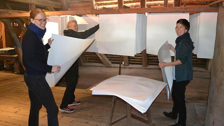 Antonia Selzer, Theresa Wedemeyer und Anne Schröter trocknen ihre wertvollen, handgeschöpften Papierbögen auf dem Trockenboden der Papiermühle Homburg.