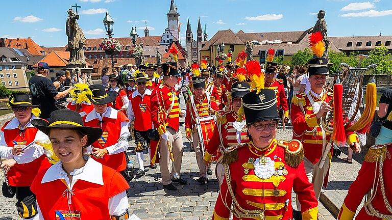 Zahlreiche Trachtengruppen ziehen am Samstag beim großen Kiliani-Festzug durch die Innenstadt in Würzburg – hier auf der Alten Mainbrücke.