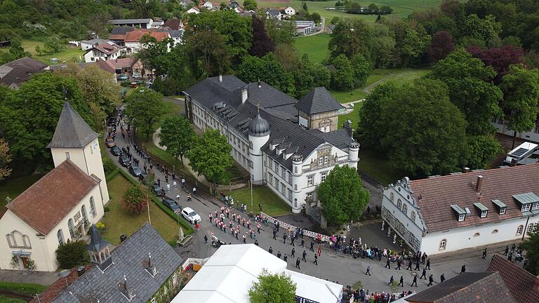 Geradezu idyllisch anzusehen, wie der Festzug sich durch die Dorfplatzmitte schlängelt dabei malerisch von Kirche, Schloss und Festzelt eingerahmt wird. Im Zentrum die 'Weisachtaler Blasmusik'.