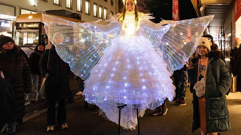Schätzungsweise 90.000 bis 100.000 Besucherinnen und Besucher kamen am Samstag zum 'Lichterglanz' bei verlängerten Öffnungszeiten in die Würzburger Innenstadt. Die leuchtenden Engel auf Stelzen waren dabei beliebte Fotomotive. Schätzungsweise 90.000 bis 100.000 Besucherinnen und Besucher kamen am Samstag zum 'Lichterglanz' bei verlängerten Öffnungszeiten in die Würzburger Innenstadt. Die leuchtenden Engel auf Stelzen waren dabei beliebte Fotomotive.