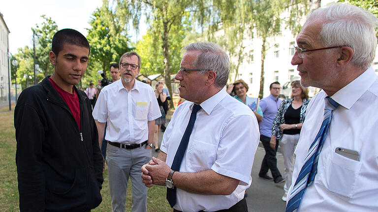 Begegnung in der Schweinfurter Erstaufnahmeeinrichtung: Sozialstaatssekretär Johannes Hintersberger (zweiter von rechts) und Regierungspräsident Paul Beinhofer (rechts) im Gespräch mit einem jungen Mann, der aus Syrien geflohen ist. Im Hintergrund Jochen Keßler-Rosa von der Diakonie. Begegnung in der Schweinfurter Erstaufnahmeeinrichtung: Sozialstaatssekretär Johannes Hintersberger (zweiter von rechts) und Regierungspräsident Paul Beinhofer (rechts) im Gespräch mit einem jungen Mann, der aus Syrien geflohen ist. Im Hintergrund Jochen Keßler-Rosa von der Diakonie.