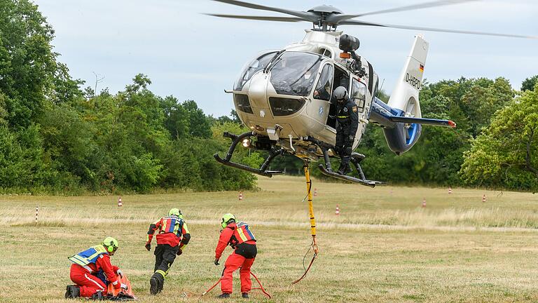 Übung für den Waldbrand-Ernstfall: Die Würzburger Feuerwehrschule bildet Flughelferinnen und Flughelfer für Löschhubschrauber aus. Zur Fortbildung gehört das Befestigen von Gegenständen an den Helikoptern.