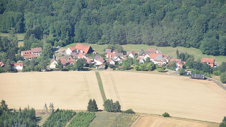 Der Wald scheint auf das kleine Dorf zuzurollen: Es dürfte keine weitere Ortschaft im Landkreis zu geben, die so dicht von Bäumen umsäumt ist wie die gesuchte.