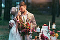 beautiful couple on wedding standing near cake and candles       -  Tipis, Traumfänger, satte Beerentöne: Noch einmal den warmen Glanz der Sonne auskosten, der Natur nahe sein - eine Trauung im Indian Summer-Style hat einen ganz besonderen Spirit.