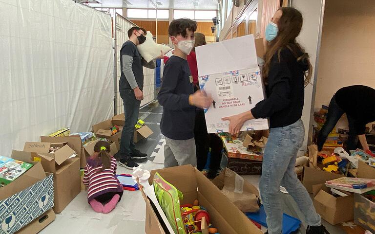 Die deutschen Schülerinnen und Schüler sortieren die zahlreichen Spielsachen, die Menschen für die geflohenen Kinder gespendet haben.