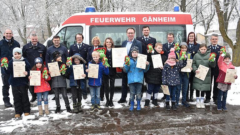 Stolz stellten sich die Kinder nach erfolgter Aufnahme in die Gänheimer Kinderfeuerwehr, mit der Feuerwehrführung  vor 'ihrem Feuerwehrauto' auf.