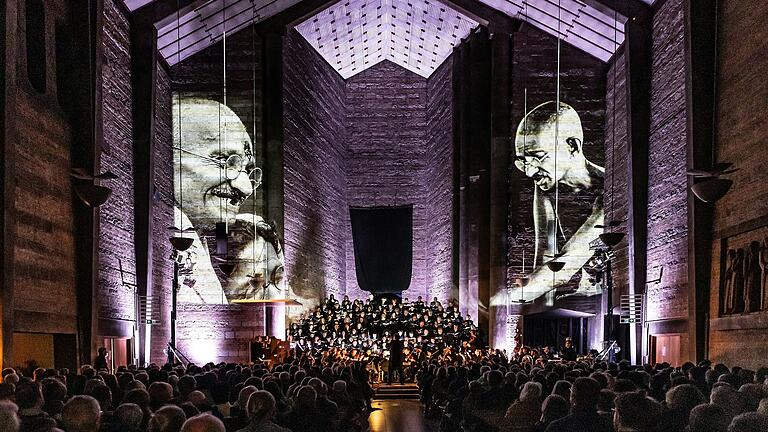 Beim Gedenkkonzert anlässlich der Zerstörung Würzburgs unterstrich eine Lichtinstallation mit Porträts historischer 'Peacemakers' – hier Mahatma Ghandi – die bewegende Musik in der Johanniskirche in Würzburg.