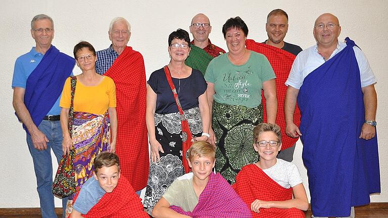 Bei einem Nachtreffen die Geschenke aus Tansania angelegt: Das Massai-Tuch der Männer und das Kanga-Tuch der Frauen. Im Bild von links Günter und Karin Schöner, Wilfried Güntner, Margarete und Erika Schwab, Ulrike Karch, Martin Busse und Gebhard Karch. Vorne die jüngsten Teilnehmer Ludwig Busse (von links) mit Tibor und Justus Lamm. Auch mit dabei waren Katja Wolz und ihre Töchter Lina und Leonie.