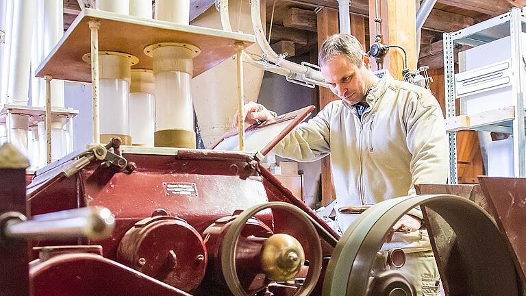 Müller Ludwig Lippert kontrolliert bei den Walzenstühlen, ob das Korn so gemahlen wird, wie es sein soll.