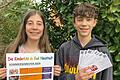 Stolz präsentieren die langjährigen Kinderuni-Studenten Eric Tapken und Amelie Tapken das neue Semesterprogramm und die Ausweise