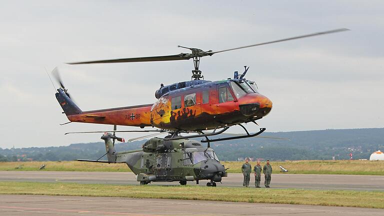 Die allerletzte Landung der sonderlackierten 'Huey'. Damit geht eine 54-jährige Dienstzeit dieses Hubschraubers zu Ende. Im Hintergrund: der neue Transporthubschrauber NH90 mit seiner Besatzung.