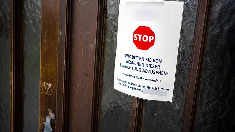 An einer Zugangstür zum Würzburger Ehehaltenhaus ist ein Schild angebracht, das von Besuchen der Einrichtung abrät. Mittlerweile sind dort vier Heimbewohner am Coronavirus gestorben.