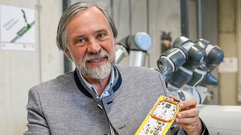 Der Würzburger Robotik- und Satellitenexperte Klaus Schilling mit einer Platine, die für neue Kleinsatelliten verarbeitet wird.