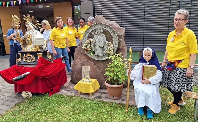 Im Mittelpunkt des abgespeckten Bildhildisfestes stand naturgemäß die heilige Bilhildis, der Gründerin des Mainzer Klosters Altomünster, die in Veitshöchheim seit 1720 als Ortspatronin verehrt wird und die Namensgeberin des Kindergartens ist. Ihr Bildnis war beim Fest gleich dreimal präsent, einmal durch die Steinstatue, die den Eingang ziert, dann durch die aus der Vituskirche entliehende Büste und schließlich durch die kleine Alessia, als die Kiga-Leiterin Angelika Vey-Rossellit mit Kindern Szenen aus dem Leben der Heiligen aufführte. Im Mittelpunkt des abgespeckten Bildhildisfestes stand naturgemäß die heilige Bilhildis, der Gründerin des Mainzer Klosters Altomünster, die in Veitshöchheim seit 1720 als Ortspatronin verehrt wird und die Namensgeberin des Kindergartens ist. Ihr Bildnis war beim Fest gleich dreimal präsent, einmal durch die Steinstatue, die den Eingang ziert, dann durch die aus der Vituskirche entliehende Büste und schließlich durch die kleine Alessia, als die Kiga-Leiterin Angelika Vey-Rossellit mit Kindern Szenen aus dem Leben der Heiligen aufführte.