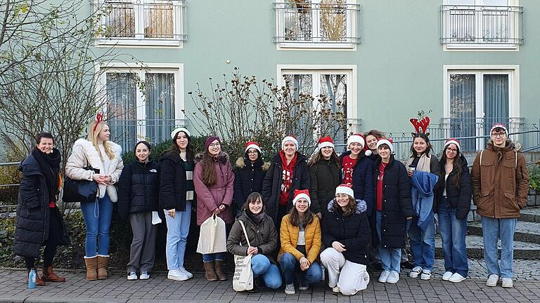 Lehrerin Lisa Bergmann zusammen mit den Schülerinnen und einem Schüler vor dem Weihnachtssingen vor der Seniorenresidenz Wiesentheid.