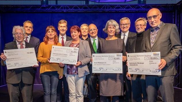 Die Vertreter der regionalen Spendenprojekte freuen sich beim Crossover-Benefizkonzert im Vogel Convention Center gemeinsam mit den vier Veranstaltern und Oberbürgermeister Christian Schuchardt über die Spendensumme von 40 000 Euro.