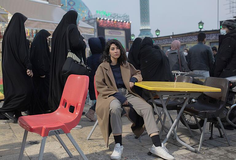 Eine Iranerin sitzt, der gesetzlichen Hijab-Vorschrift trotzend, auf einem Stuhl an einem belebten Platz in Teheran im Dezember 2022. Die massiven Proteste im Iran begannen nach der Verhaftung und dem Tod von Masha Amini, einer 22-jährigen Kurdin, die von der Sittenpolizei der Islamischen Republik wegen eines angeblichen Verstoßes gegen die gesetzliche Hijab-Vorschrift festgenommen worden war. Eine Iranerin sitzt, der gesetzlichen Hijab-Vorschrift trotzend, auf einem Stuhl an einem belebten Platz in Teheran im Dezember 2022. Die massiven Proteste im Iran begannen nach der Verhaftung und dem Tod von Masha Amini, einer 22-jährigen Kurdin, die von der Sittenpolizei der Islamischen Republik wegen eines angeblichen Verstoßes gegen die gesetzliche Hijab-Vorschrift festgenommen worden war.
