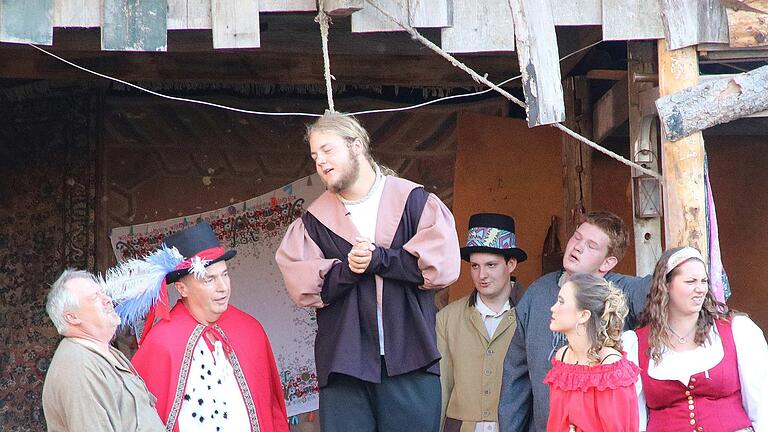 Vor dem Galgen wurde Dichter Gringoire (Max Heuchler, Mitte) durch eine Scheinehe mit Esmeralda (rechts daneben, im roten Kleid) in letzter Sekunde gerettet.  Foto: Dieter Britz       -  Vor dem Galgen wurde Dichter Gringoire (Max Heuchler, Mitte) durch eine Scheinehe mit Esmeralda (rechts daneben, im roten Kleid) in letzter Sekunde gerettet.  Foto: Dieter Britz