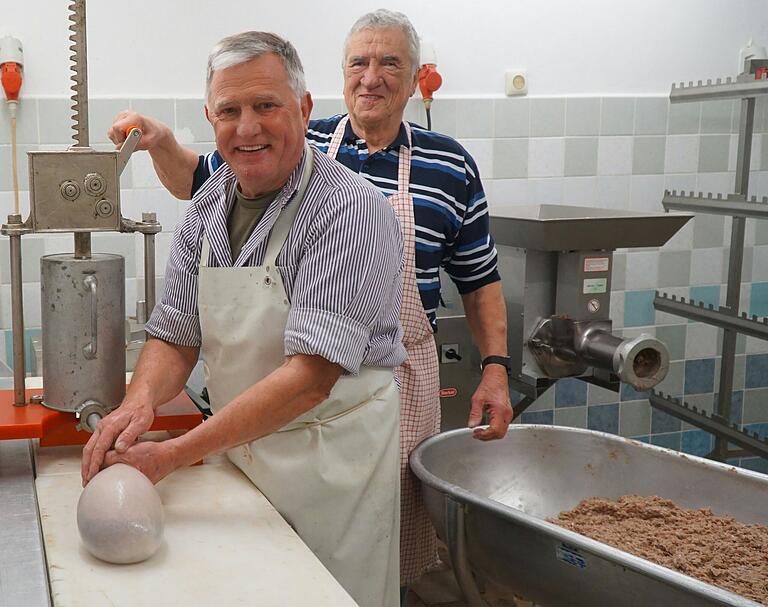 von links: Dieter Laur füllt die erste Schweineblase mit Wurstmasse, im Hintergrund Altbürgermeister Alfred Frank dreht an der Füllmaschine von links: Dieter Laur füllt die erste Schweineblase mit Wurstmasse, im Hintergrund Altbürgermeister Alfred Frank dreht an der Füllmaschine